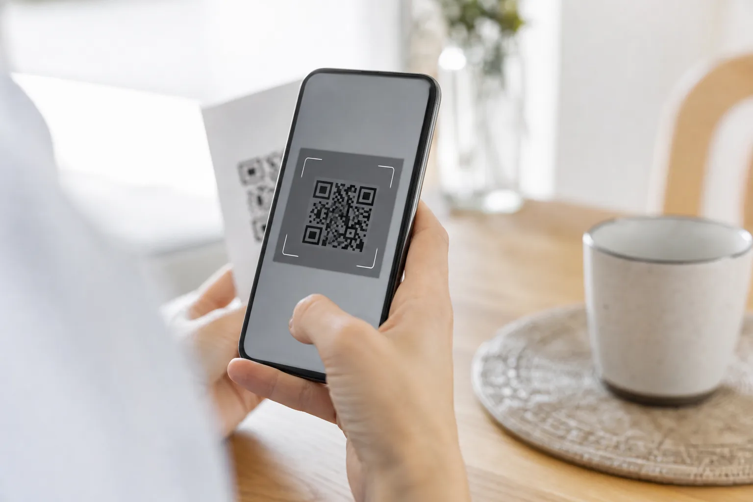 Hand som skannar en QR-kod på mobilen för att aktivera ett eSIM-abonnemang